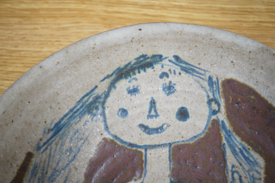 Eric James Mellon (1925-2014), a studio pottery dish, painted with a girl and cat, inscribed and dated 1971 to the foot rim, 29cm in diameter